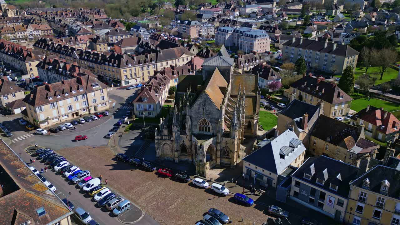 Historic Eglise de la Trinité, Trinity church and surrounding town in Normandy, France. aerial drone sideways