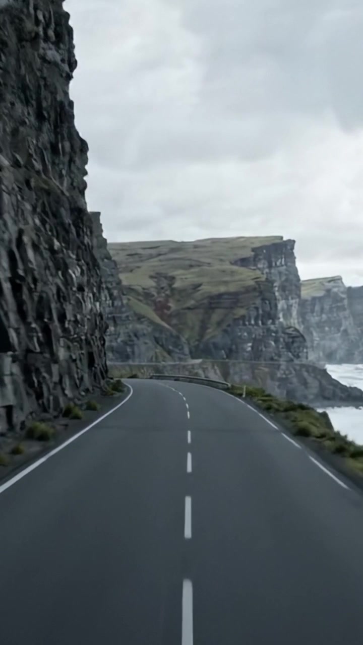 Panoramica strada costiera lungo scogliere drammatiche e onde che si infrangono, catturata in due cornici distinte, che mostra la bellezza grezza e la tranquillità della natura in una giornata cupa.