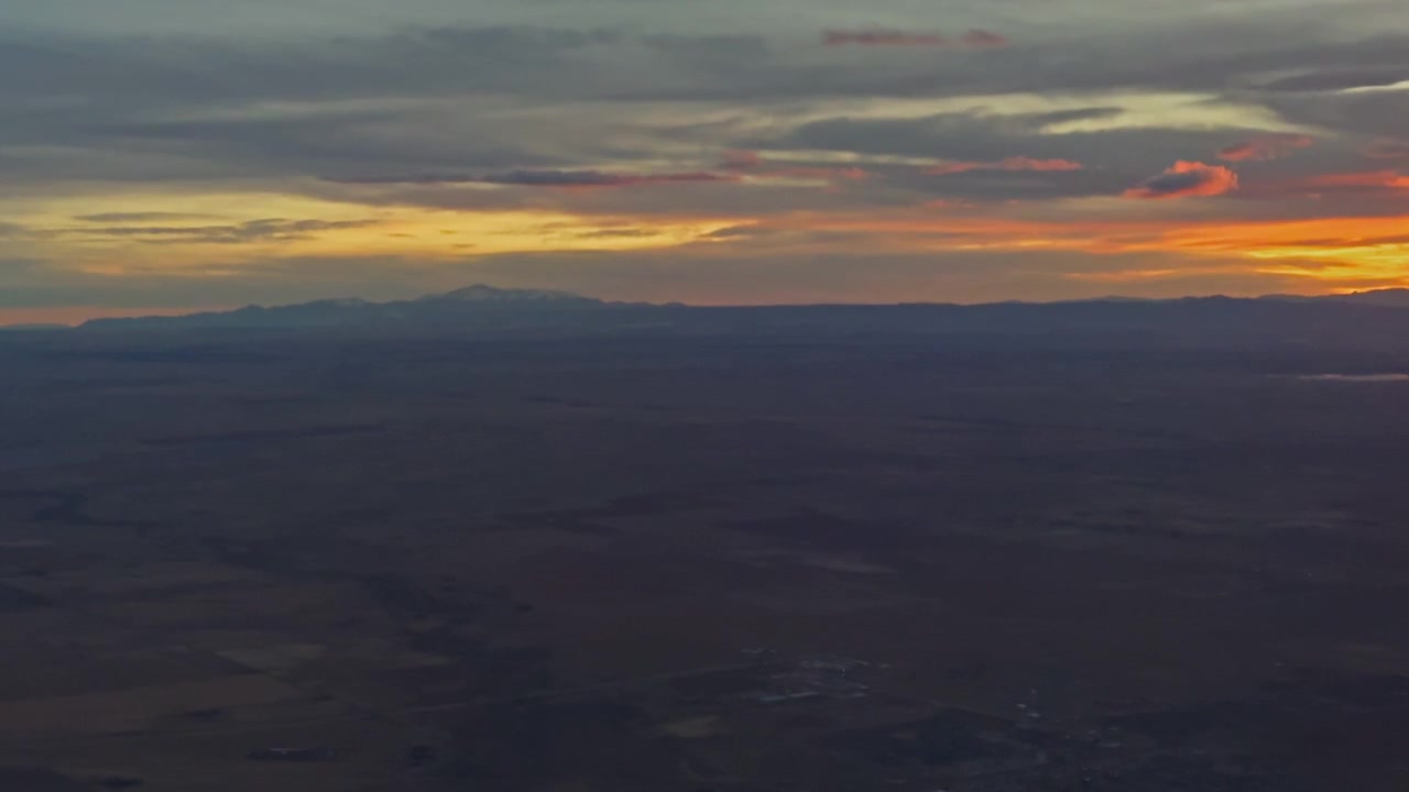 Warm sunset sky with glowing horizon and layered cloud formations from aircraft
