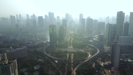 bird view of of jakarta city with skyscrapers and the new semanggi road junction in the misty morning, shot in 4k resolution