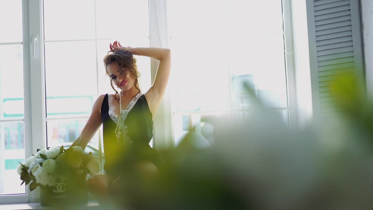Playful seductive young woman near window. Playful seductive young woman near window in light bedroom