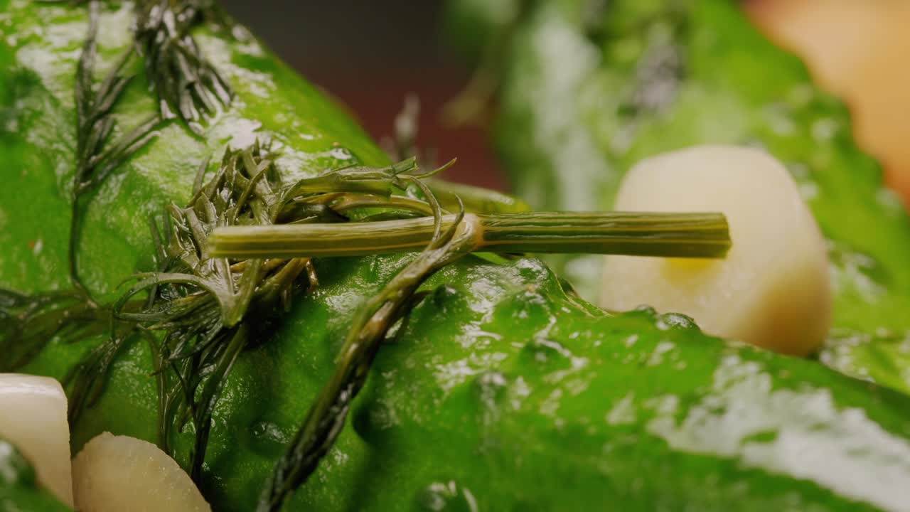 Close-up of fermented cucumbers with garlic and dill on plate. Preservation of vegetables in glass jars. Fermentation preserved cucumbers with spices. Russian cuisine.