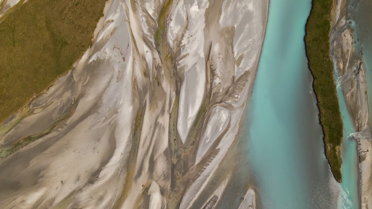 Top-down drone footage of a glacier river delta with turquoise water