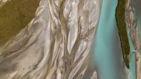 top-down drone footage of a glacier river delta with turquoise water