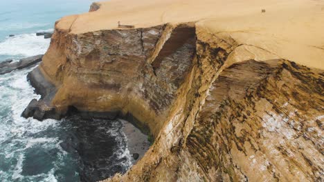 Orbitale-Aufnahme-Von-Riesigen-Klippen-Am-Meer,-Während-Vögel-Zu-Ihrem-Nistplatz-Fliegen