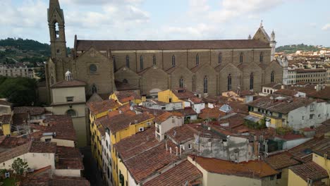 Un-Dron-Se-Eleva-Entre-Un-Callejón-De-Un-Edificio-Para-Revelar-La-Basílica-De-Santa-Croce-En-Florencia,-Italia.