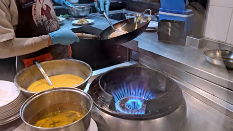 stir frying and cooking the famous thai dish pad thai in a restaurant in bangkok, thailand