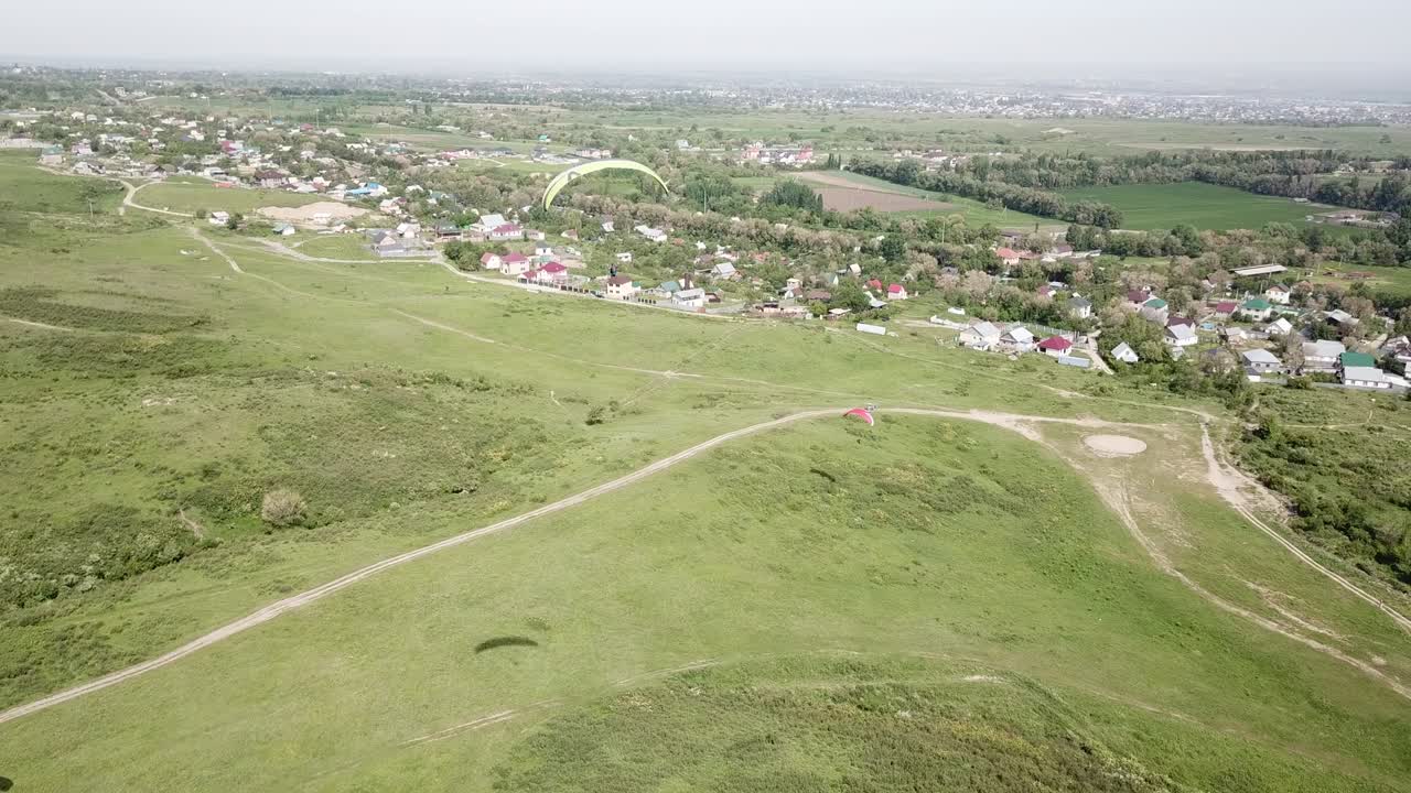 parapenteo en las montañas, campos verdes, colinas