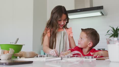 Felices-Hermanos-Caucásicos-Horneando-Juntos,-Preparando-Galletas-En-La-Cocina