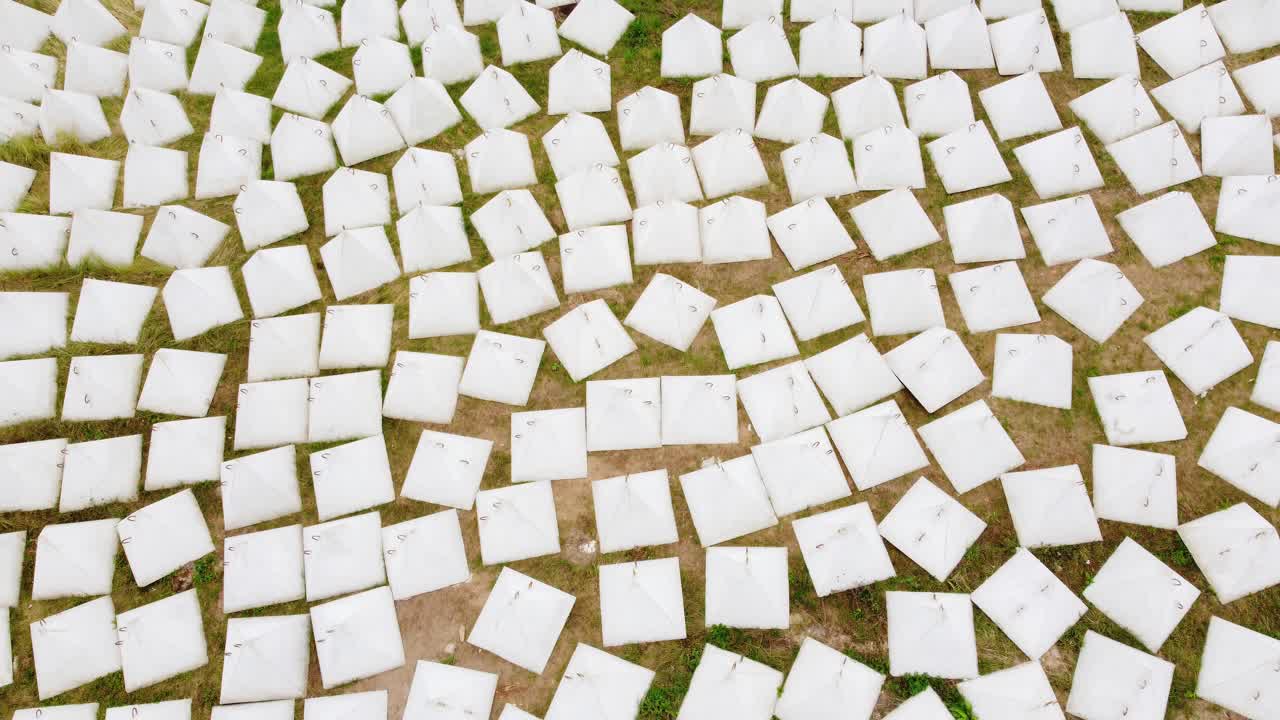 Aerial View of Numerous White Pyramid-Shaped Concrete Structures on Grassy Ground