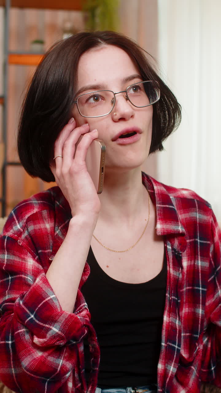 Young woman talking on smartphone smiling with joy and using expressive hand movement during call
