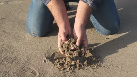 human hand grasping sand