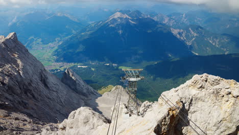 Top-down-view-of-cable-car-lines-and-tower-on-mountain-in-Zugspitze,-Germany