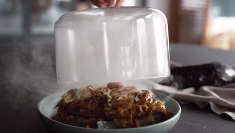 thinly sliced eggplant, creamy filling, and a hint of smoke under a glass lid create a unique culinary experience, marrying elegant presentation with tantalizing aromas