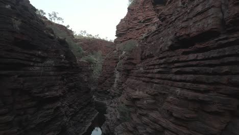 AERIAL---Flying-above-a-gorge-in-Karijini-National-Park,-Australia,-forward