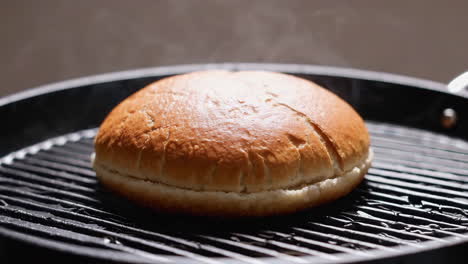 cooking a burger bun on a griddle