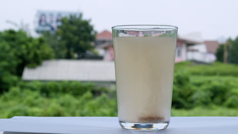 a glass filled with water and a tablet of antacid to cure heartburn caused by gastric acid in the stomach