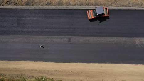 road roller machine rolls asphalt. aerial view on the road rollers working on the new road construction site