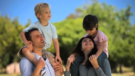 children laughing on the shoulders of parents