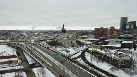 Vista-Panorámica-De-La-Basílica-De-Santa-María,-El-Horizonte-De-Minneapolis-Con-El-Tráfico-Que-Pasa-Por-Debajo