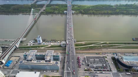 Busy-trafficked-road-intersection-and-bridge-crossing-river-in-Vienna,-aerial