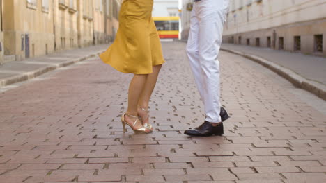 close-up de um casal irreconhecível dançando bachata na rua da cidade velha