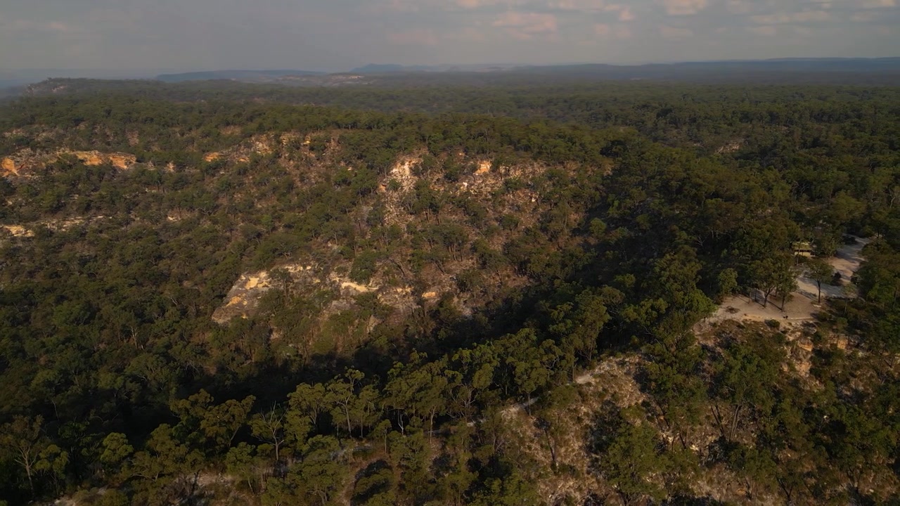 Isla Gorge Milli Parkı'nın yürüyüş parkurları ve kamp alanı üzerinde, gün batımında soldan sağa havadan görünümler, Queensland, Avustralya.