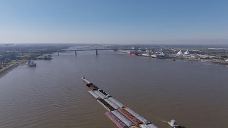 Amplias-Imágenes-Aéreas-De-Un-Par-De-Remolcadores-Empujando-Una-Gran-Cantidad-De-Barcazas-En-El-Río-Mississippi-En-Baton-Rouge,-Luisiana.