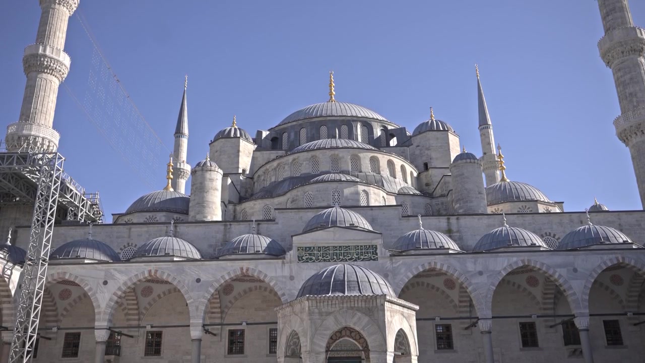 Filmato cinematografico in 4K dell'esterno della Moschea del Sultano Ahmed (Moschea Blu), che mostra le sue cupole a cascata, sei minareti e il cortile ad arco. Cielo azzurro limpido, Istanbul, Turchia.