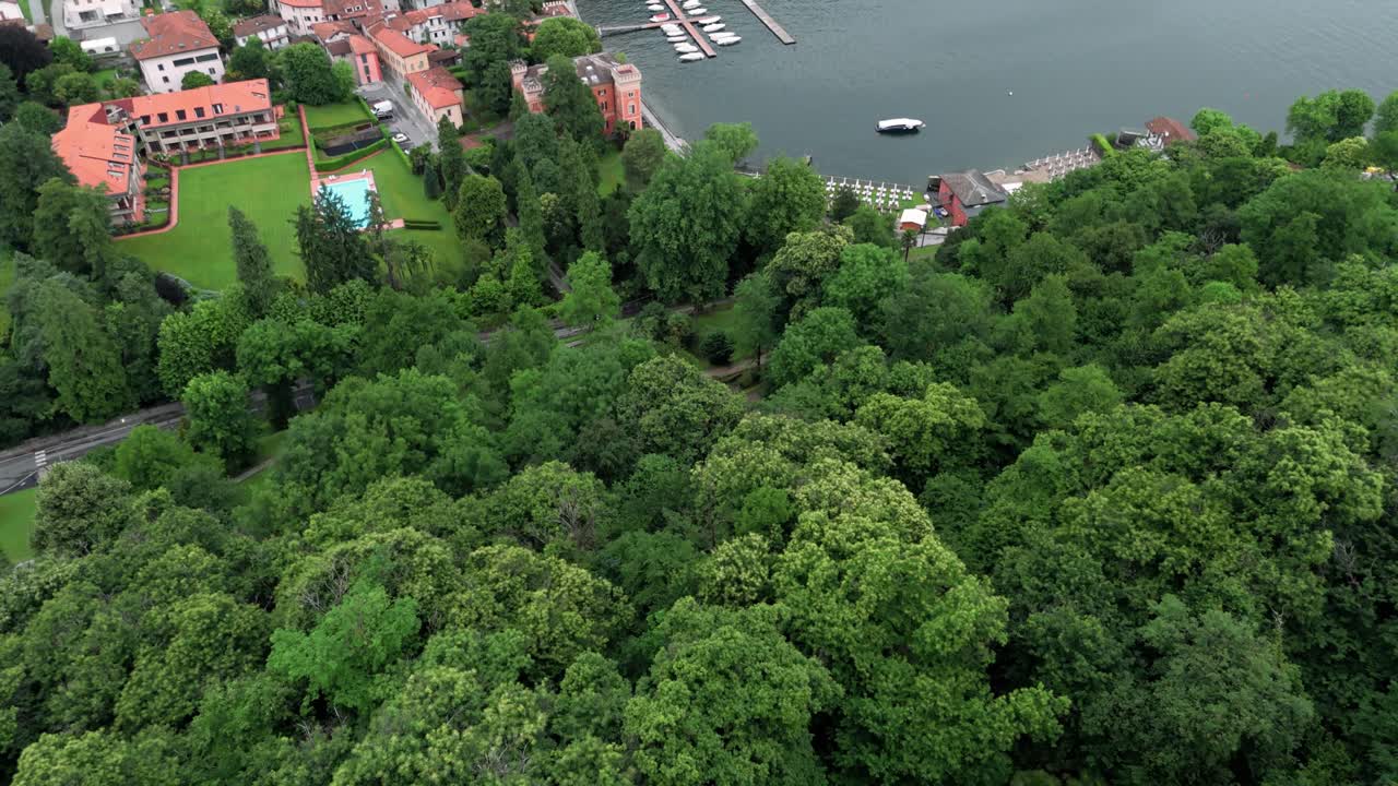 Letecký záběr odhalující vesnici Lenno v Itálii u jezera Como blízko slavné Vily Balbianello, ukazující její malý přístav a lodě podél panoramatu města