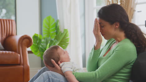 Madre-Amorosa-Jugando-Al-Escondite-Con-Su-Hijo-Sentado-En-El-Suelo-En-Casa