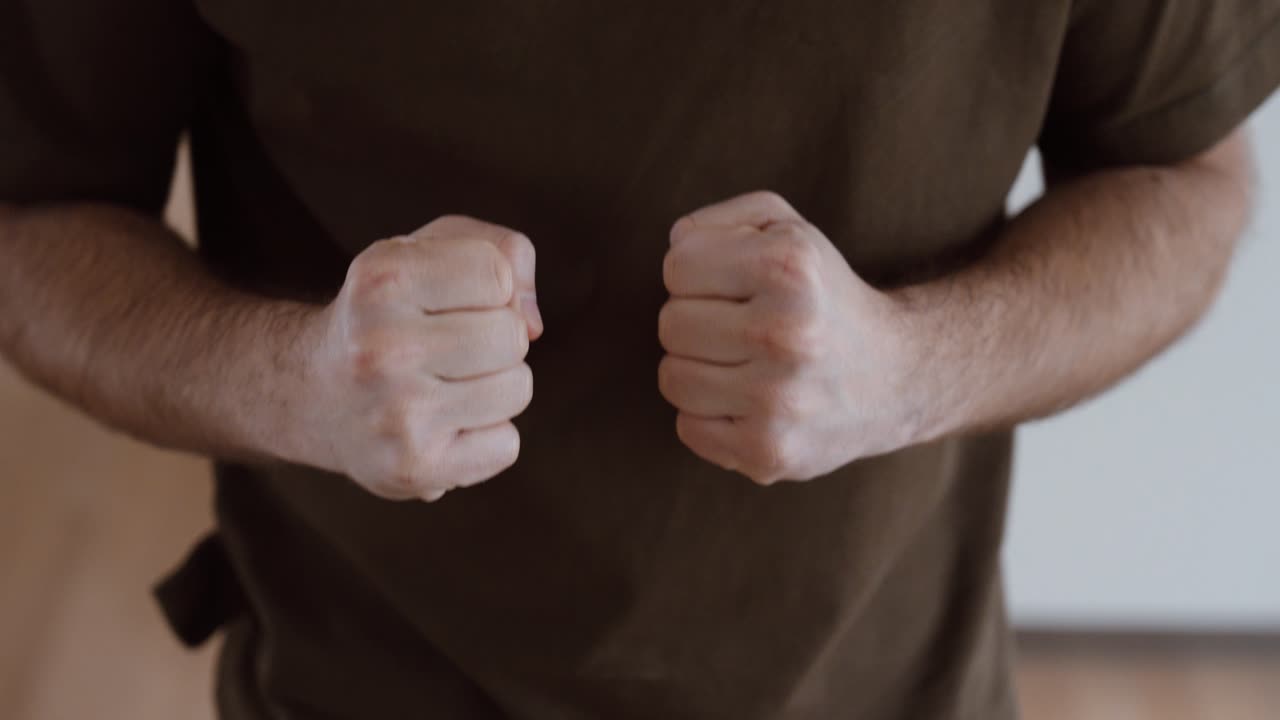 Close-up de um homem com as duas mãos cerradas em punhos. Conceito de raiva, agressão, determinação, conflito, estresse e tensão emocional