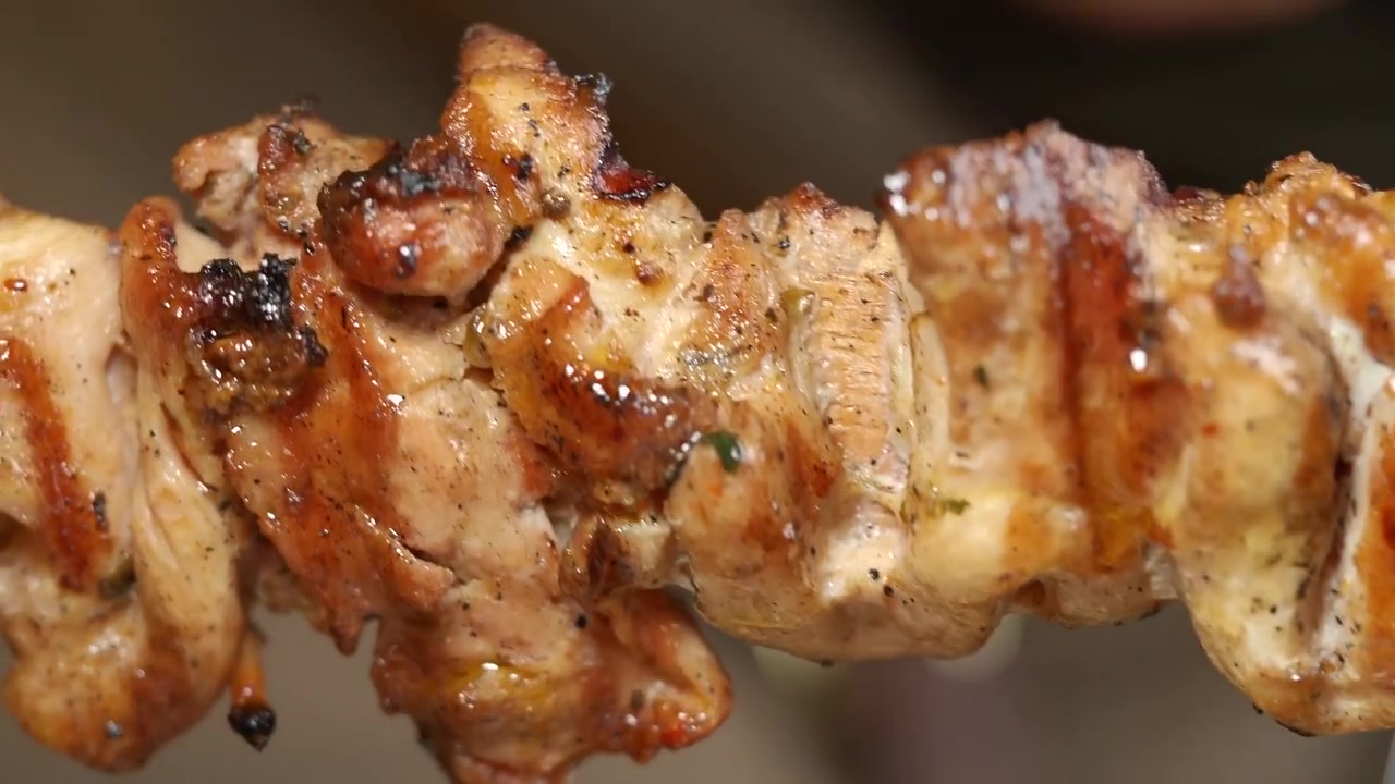 Primo piano di uno spiedino di pollo alla griglia che ruota.