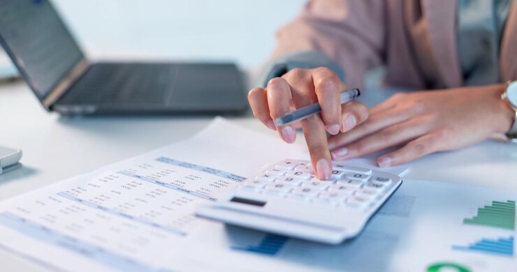 Commercialista Professionista che Usa la Calcolatrice ed Esamina Documenti Finanziari