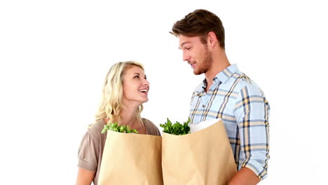 una atractiva pareja de jóvenes con bolsas de comestibles