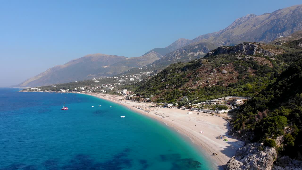 Beautiful seaside with resorts and tourist villas on hills above beach and blue azure water in Albania