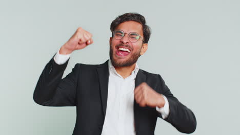 un hombre de negocios feliz mostrando un gesto de rock n roll, una señal genial, una expresión loca bailando, victoria, victoria