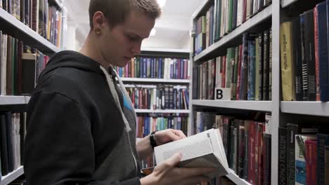 joven mirando libros en una biblioteca