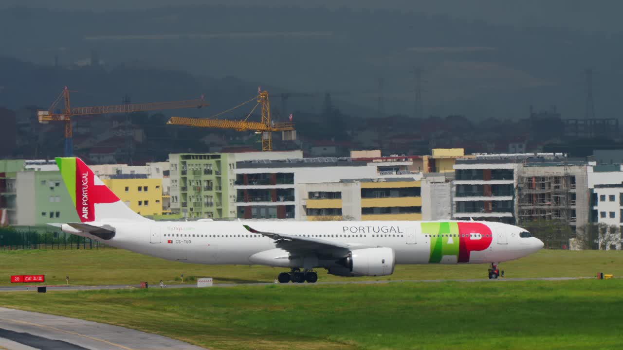 Aterrizaje de un TAP Air Portugal A330neo en Lisboa con edificios coloridos de la ciudad