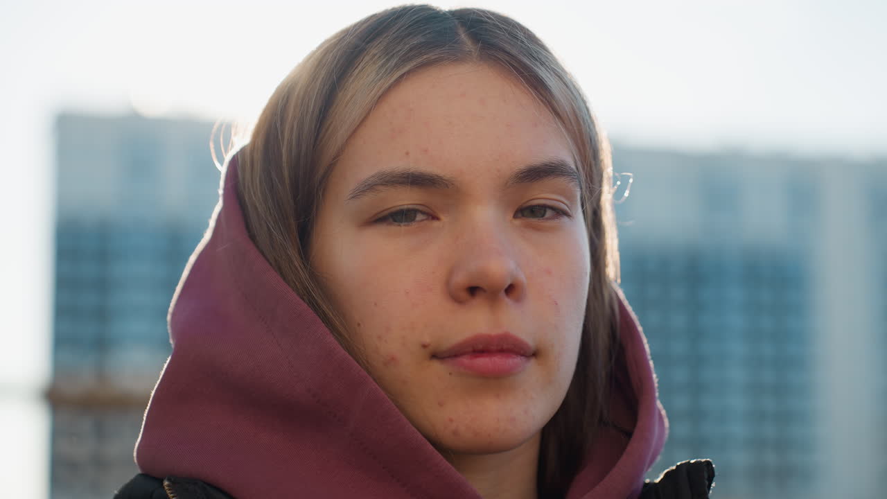 Portrait of strong willed trainee under bright sun rays shining across determined face, close up capturing resilient gaze and empowering mood during outdoor workout session in urban park setting