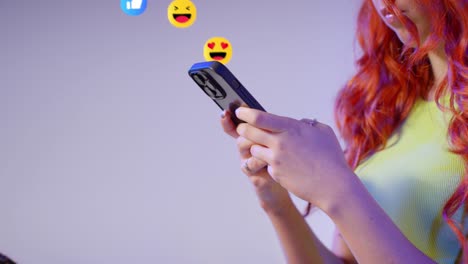 primer plano de una mujer de la generación z mirando un teléfono móvil con emojis de gráficos en movimiento que muestran múltiples notificaciones de redes sociales gustando y reaccionando al contenido en línea