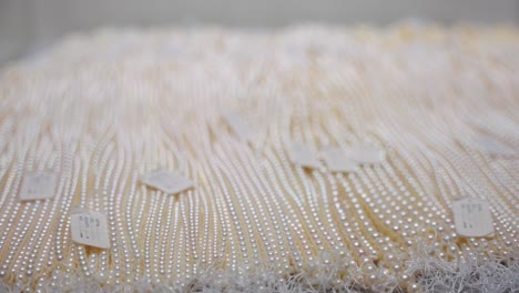 precious pearl necklaces laid out on display, mikimoto peal island 4k