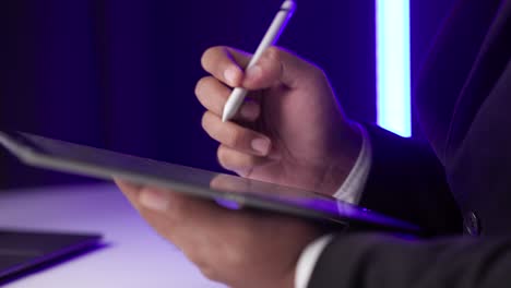 firma electrónica en el cuarto oscuro. hombre de negocios firmando un contrato de negocios con bolígrafo en la tableta. hombre firmando contrato en la tablet en la oficina por la noche. concepto de negocios y tecnología.