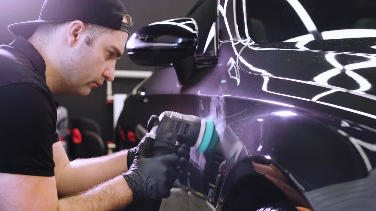 페인트 복원을 위해 기계와 폴리셔를 사용하는 전문 자동차 디테일링.