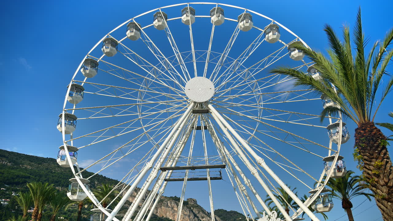 White Ferris Wheel with the blue sky on the background in Menton, France