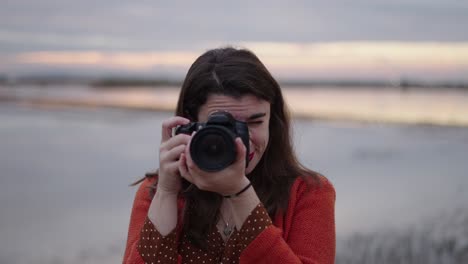 woman taking pictures at sunset