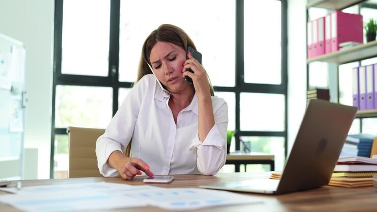 Busy Businesswoman Multitasking with Multiple Phones in Office