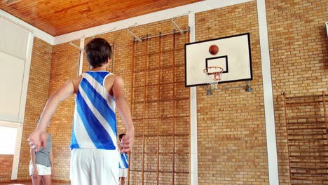 school students playing basketball in basketball court