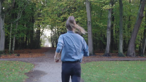 medium shot of a running woman in a park on a sunny morning