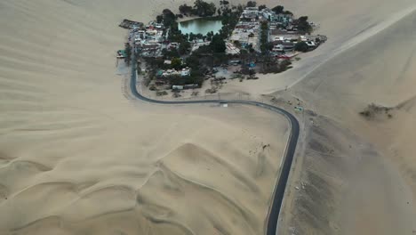aerial reveal of famous huacachina village in the peru sand dune desert